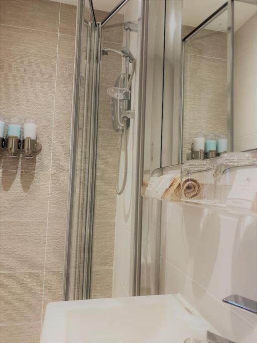 a bathroom with a shower and a mirror at THE PAD by the beach Penthouse apartment with sunset and city views in Bournemouth