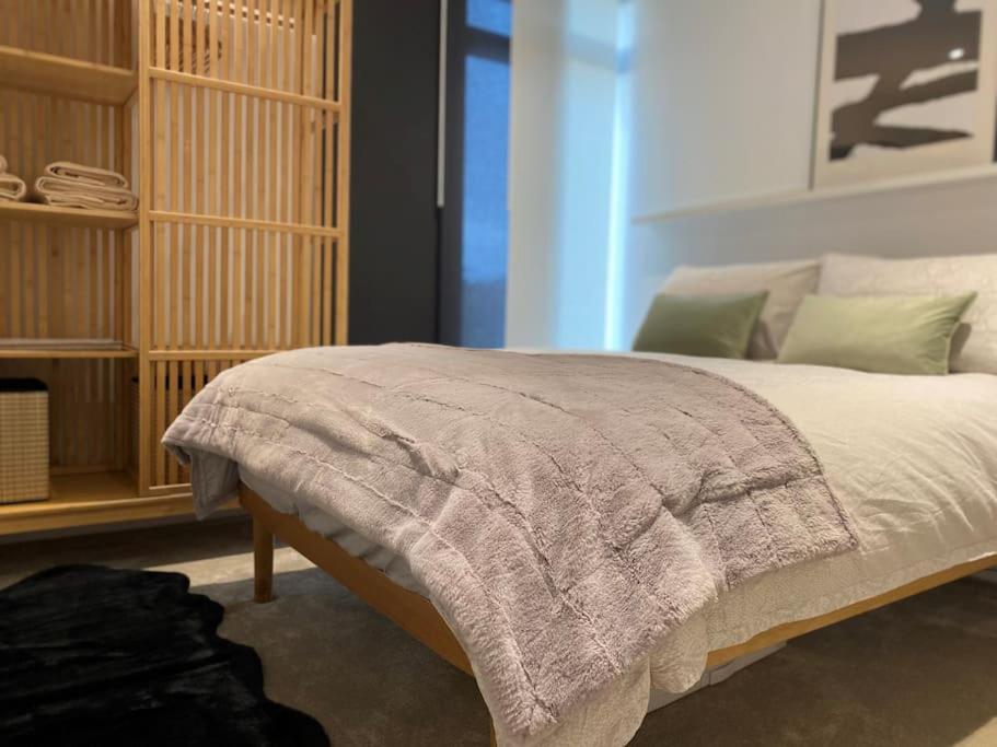 a bedroom with a bed with a blanket on it at THE PAD by the beach Penthouse apartment with sunset and city views in Bournemouth