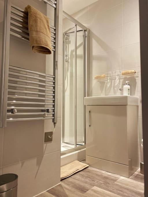 a white bathroom with a shower and a sink at THE PAD by the beach Penthouse apartment with sunset and city views in Bournemouth