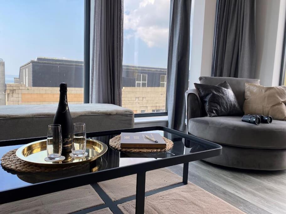 a living room with a couch and a table at THE PAD by the beach Penthouse apartment with sunset and city views in Bournemouth