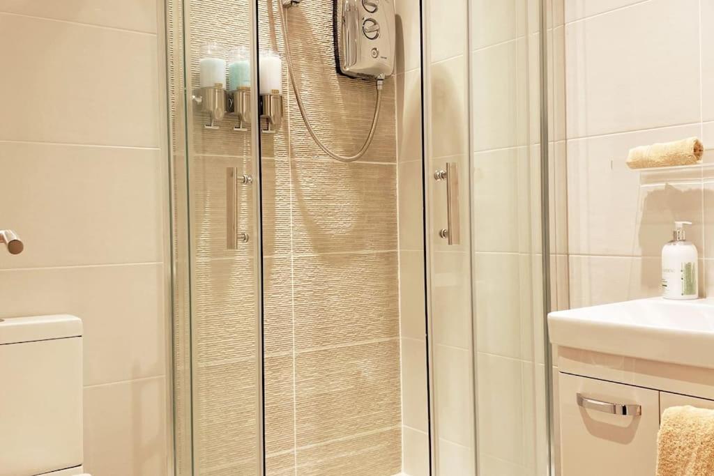 a shower with a glass door in a bathroom at THE PAD by the beach Penthouse apartment with sunset and city views in Bournemouth