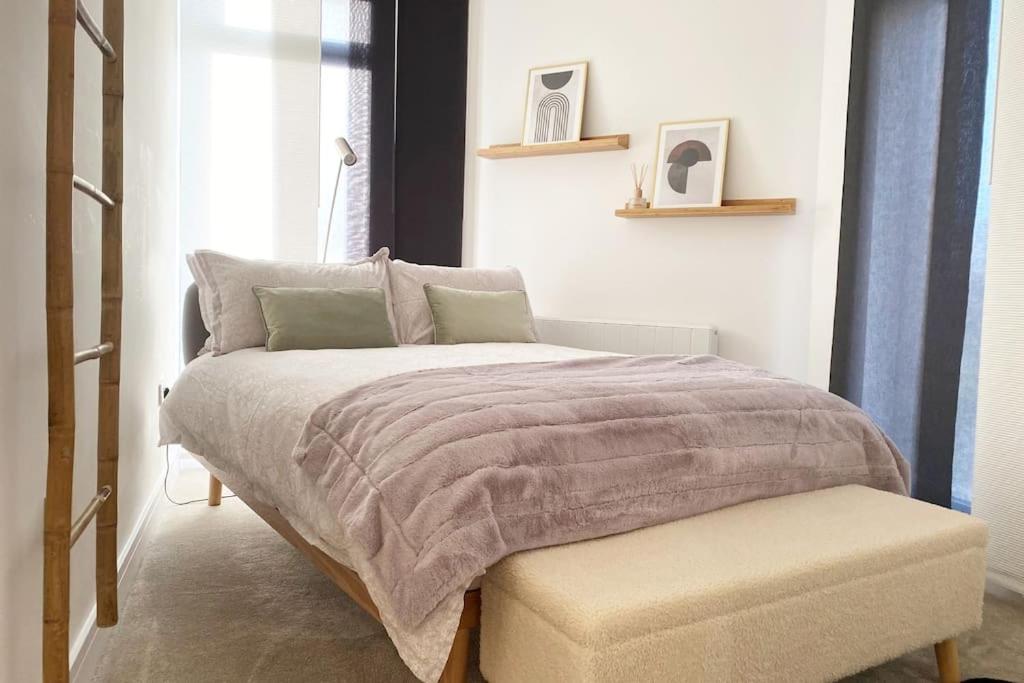 a bedroom with a bed with a ottoman next to a window at THE PAD by the beach Penthouse apartment with sunset and city views in Bournemouth