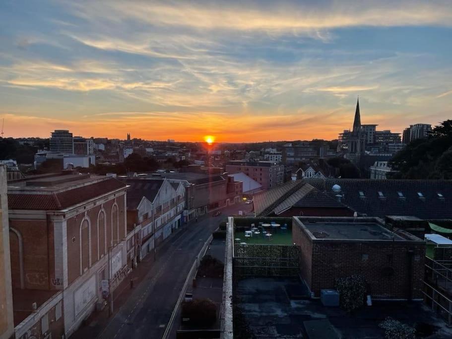 a view of a city with the sunset in the background at THE PAD by the beach Penthouse apartment with sunset and city views in Bournemouth