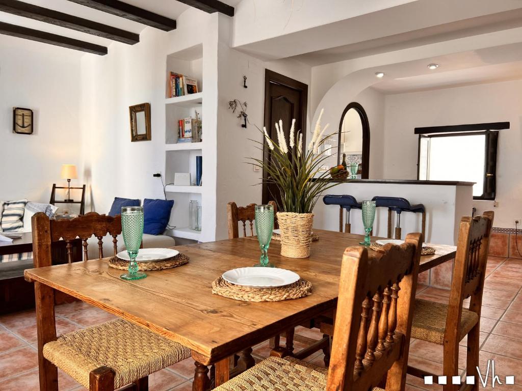 uma sala de jantar com uma mesa de madeira e cadeiras em VH CostaBlanca - APARTAMENTO RIVIERA em Moraira