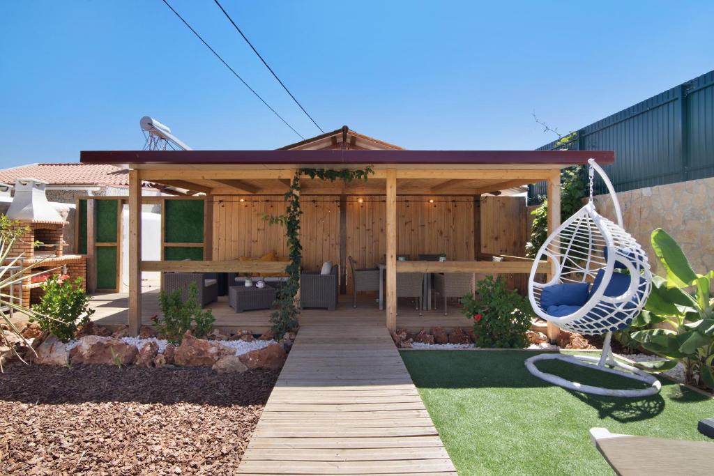 a garden with a wooden pergola and a swing at Casa de Aloe in Paderne