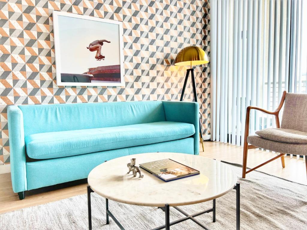 un soggiorno con divano blu e tavolo di The Leo - One Bedroom Apartment W Private Balcony a San Diego
