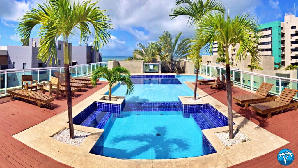 una piscina en la azotea de un edificio con palmeras en Vacanze - Austrália (JTR) en Maceió