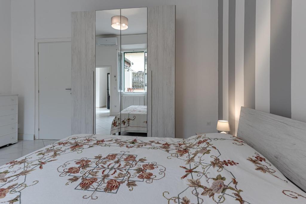 - une chambre dotée d'un lit avec un couvre-lit floral dans l'établissement Wilma Apartment, à Calenzano