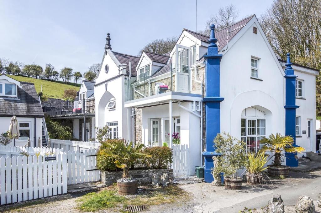 a row of white houses with blue trim at The Coach House - 3 Bedroom Holiday Home - Penally - Tenby in Penally