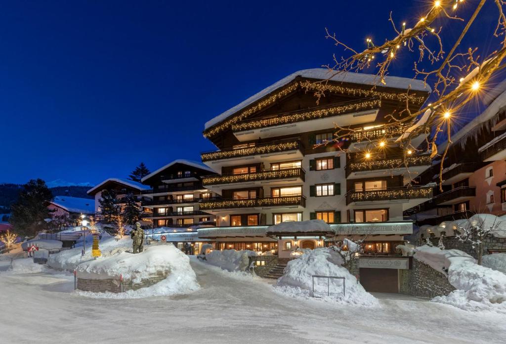 um grande edifício na neve à noite em Seven Alpina Boutique Hotel em Klosters Serneus