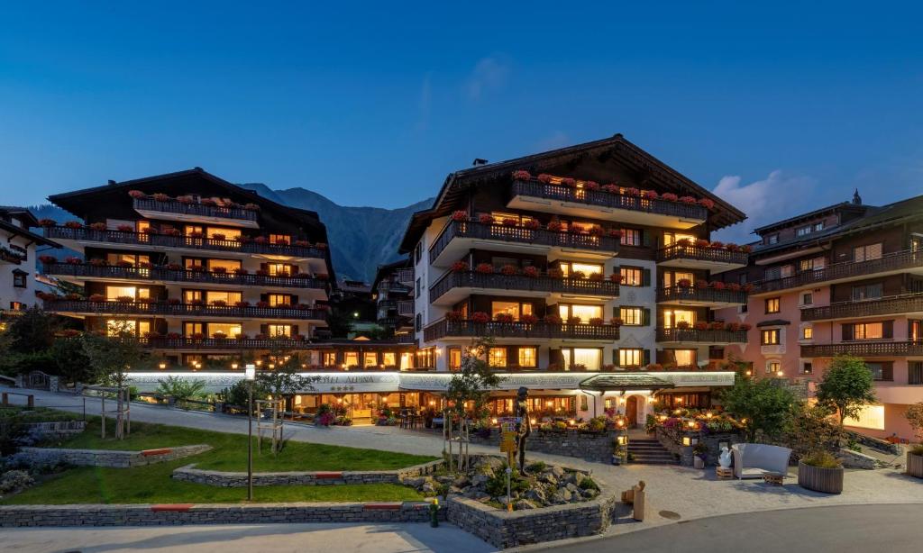 ein Hotel in einem Resort mit Bergen im Hintergrund in der Unterkunft Seven Alpina Boutique Hotel in Klosters Serneus