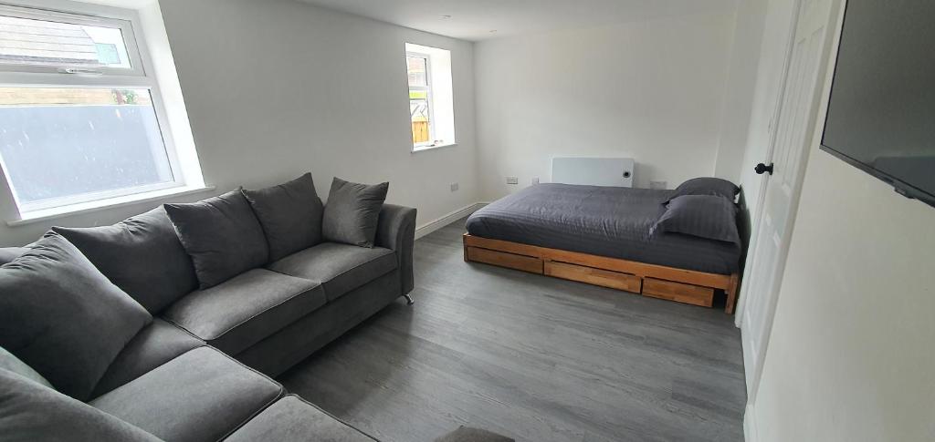 salon z kanapą i łóżkiem w obiekcie Kovalam w mieście Clacton-on-Sea
