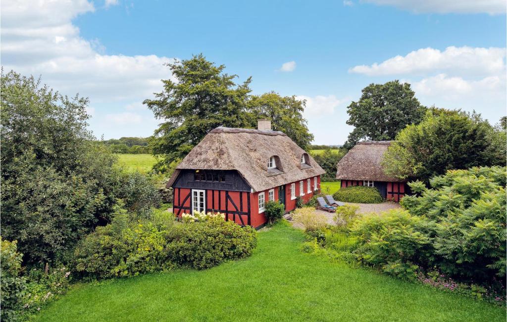 an old red barn with a thatched roof in a field at Pet Friendly Home In Vejle With Kitchen in Vejle