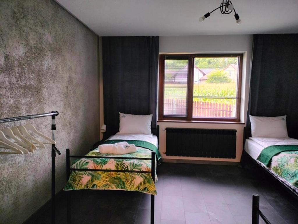 een kamer met 2 bedden en een raam bij Apartamenty na Zatorskiej - Noclegi Energylandia, Oświęcim, Zator 