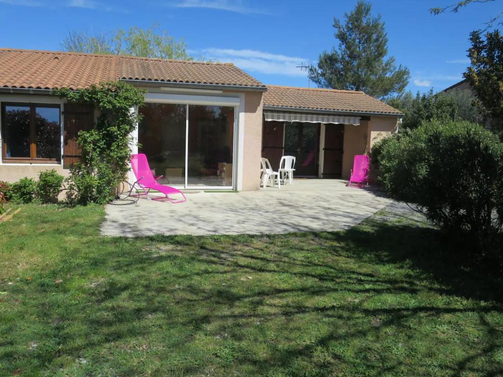 a house with pink chairs in a yard at Maison Indépendante 3étoiles avec grand jardin in Saint-Germain