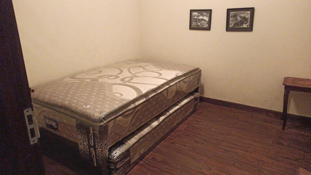 ein kleines Bett in einer Ecke eines Zimmers in der Unterkunft Notes From The Mountains in Bandung