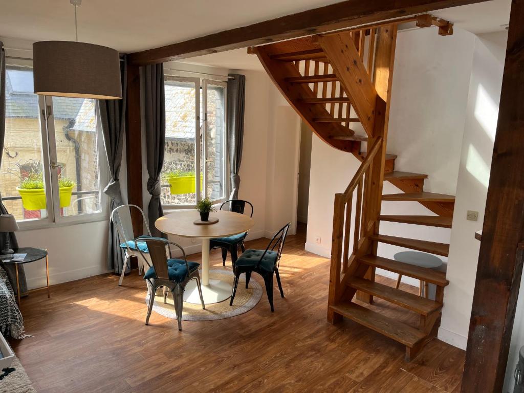 a room with a table and chairs and a staircase at Duplex Beauregard - calme & proche de la plage in Dieppe