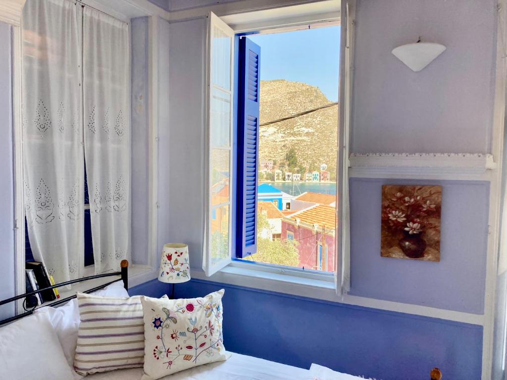 a bedroom with a bed and a window with a view at Chroma Kastellorizo in Meyisti