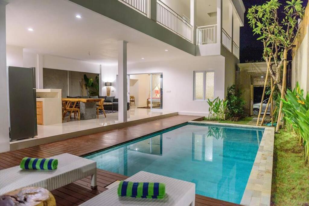 a swimming pool in a house with a living room at Selog Villa 4 in Seminyak