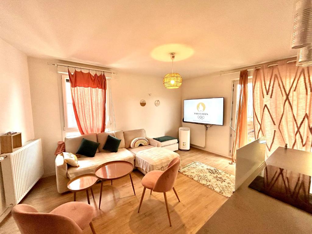 - un salon avec un canapé et une télévision dans l'établissement Appartement JO 2024, à Bezons