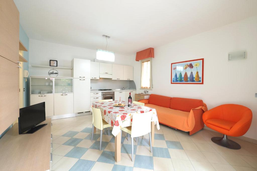uma cozinha e sala de estar com uma mesa e um sofá em We Home - PALESTRINA17 - Riccione sul mare em Riccione