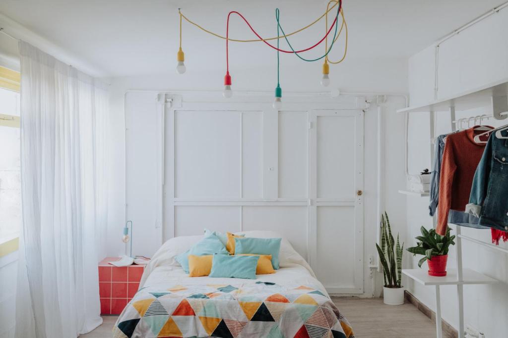 een slaapkamer met een bed met een kleurrijke deken bij El garage in Esquel