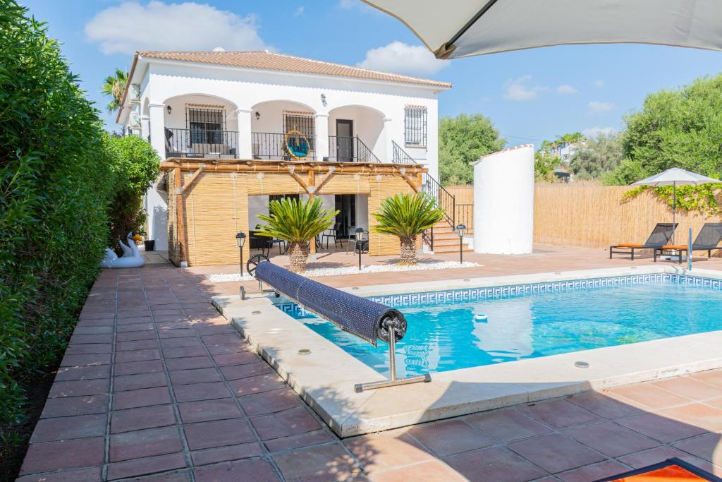 a swimming pool in front of a house at Casa de Ámbar, Bed&Breakfast in Alhaurín el Grande