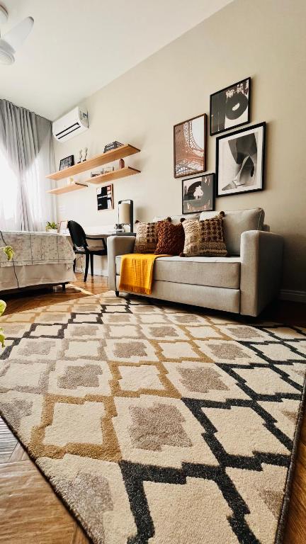Hotel Vista para o Cristo no coração de Copacabana, a living room with a couch and a rug at Vista para o Cristo no coração de Copacabana in Rio de Janeiro
