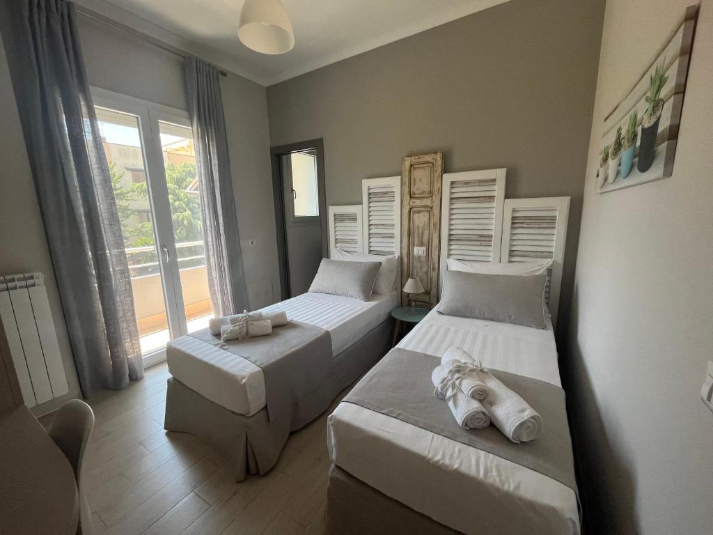 1 dormitorio con 2 camas y ventana en B&B L’ALTRAMURGIA, en Cassano delle Murge