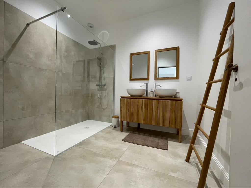 een badkamer met 2 wastafels en een glazen douche bij Château de la Busquette - in La Magdelaine-sur-Tarn