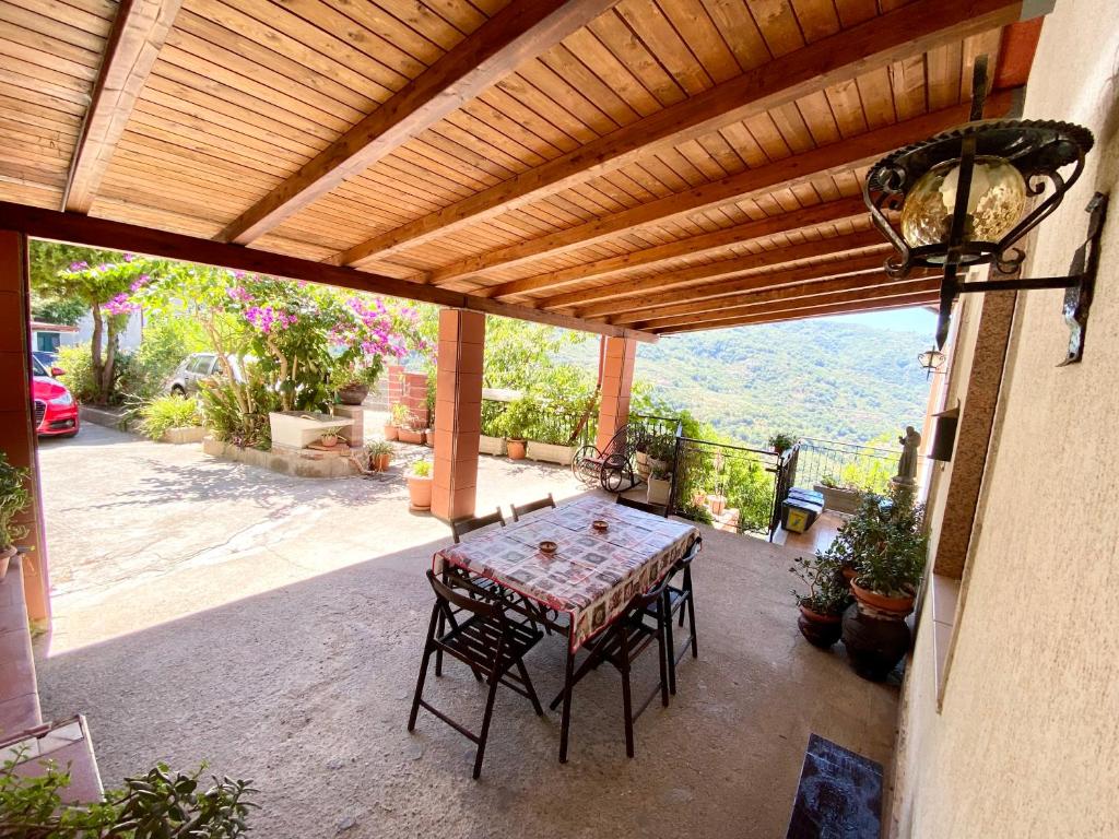 d'une terrasse avec une table et des chaises sous une pergola. dans l'établissement Villa Maria - Sant'Angelo di Brolo, à Contura