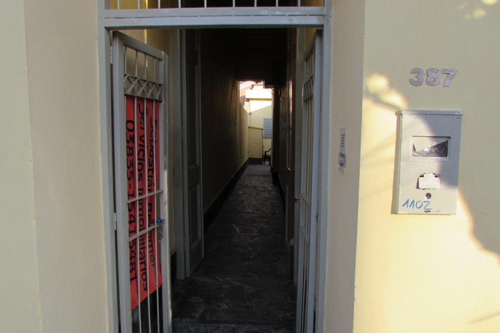 einen Flur, der in ein Zimmer mit einem Flur führt, der in ein Zimmer mit einer Tür führt in der Unterkunft Hostel Céntro Belén in Belén