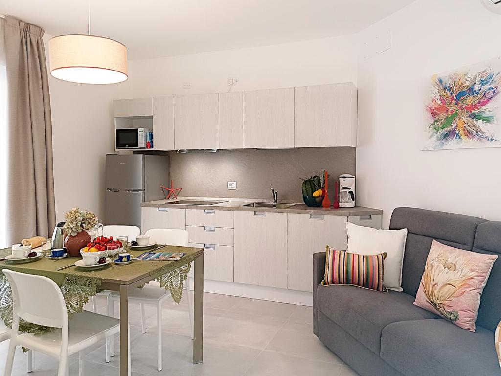 cocina y sala de estar con mesa y sofá en Residence Green Life, en Bibione