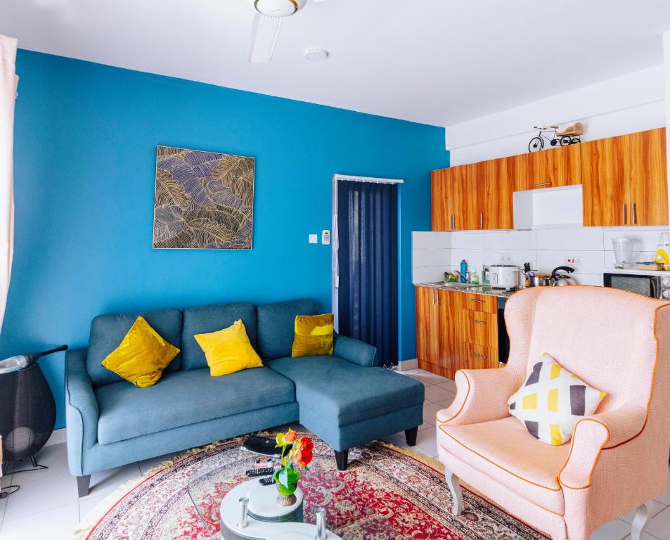 ein blaues Wohnzimmer mit einem Sofa und einem Stuhl in der Unterkunft Fumbatown Cozy 1 bed Apartment in Fumba