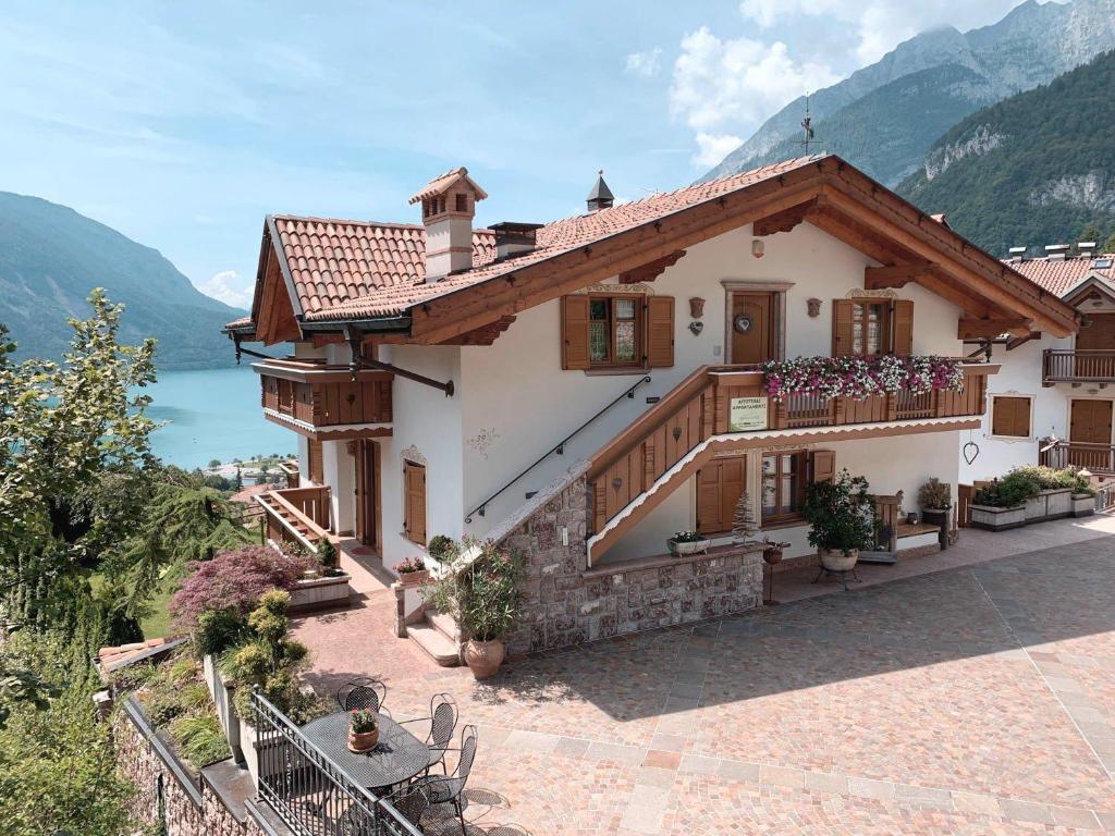 ein großes Haus mit einem Balkon und einem See in der Unterkunft Villa la Dama del Lago in Molveno