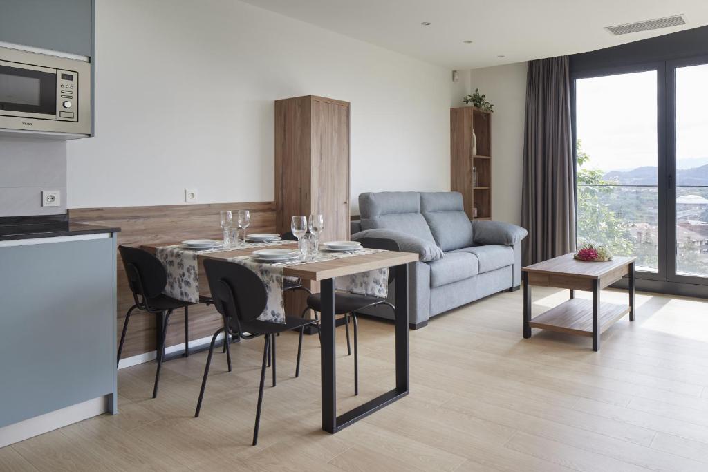 een keuken en een woonkamer met een tafel en een bank bij MANTULENE Apartments - Basque Stay in San Sebastian