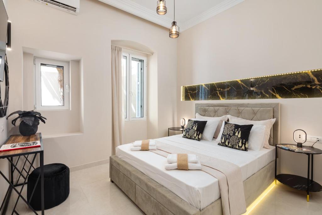 um quarto com uma cama grande e paredes brancas em Modern-Vintage Old Town Suites em Corfu Town