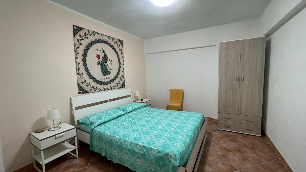 - une chambre avec un lit, une table et une armoire dans l'établissement Appartamento L'Ulivo, à Brancaleone Marina