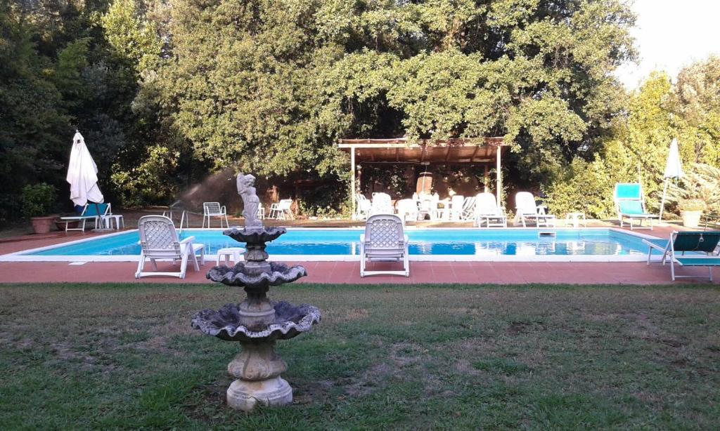 una fuente en el césped junto a una piscina en Villa Marilu, en Capannori