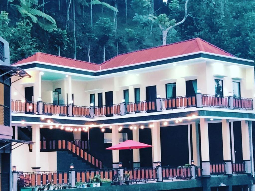 duży biały dom z czerwonym dachem w obiekcie Villa Neng Dewi w mieście Cisarua