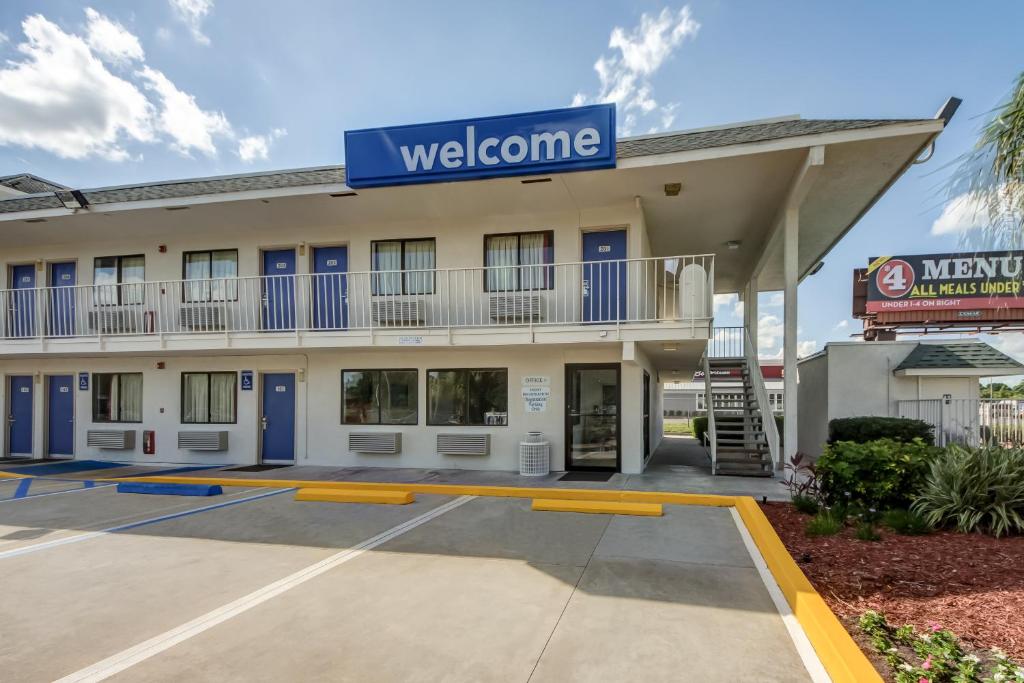 a welcome sign for a hotel with a parking lot at Motel 6-Lakeland, FL in Lakeland