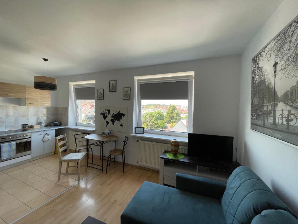 ein Wohnzimmer mit einem Sofa und einer Küche in der Unterkunft Apartament Bea Mar in Gdynia