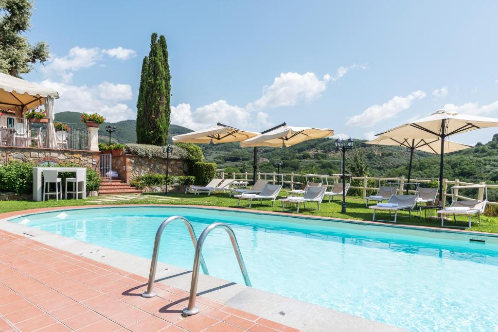 a large swimming pool with chairs and umbrellas at Agriturismo - Collina Toscana Resort in Monsummano Terme