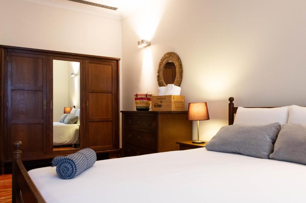 a bedroom with a white bed and a mirror at Fradelos Porto Centro in Porto