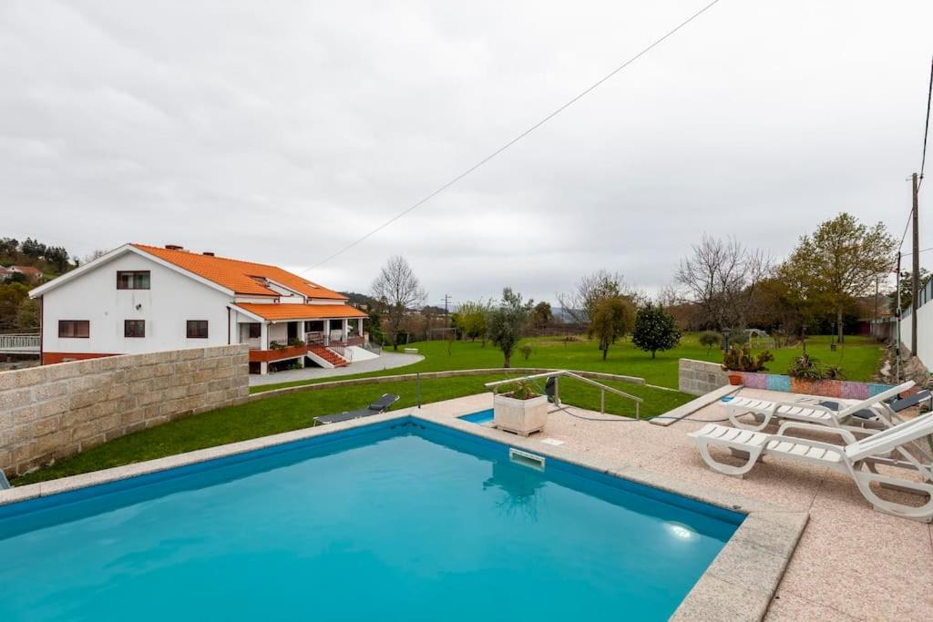 una piscina con una casa sullo sfondo di Maison avec piscine : quinta do sol ad Amarante