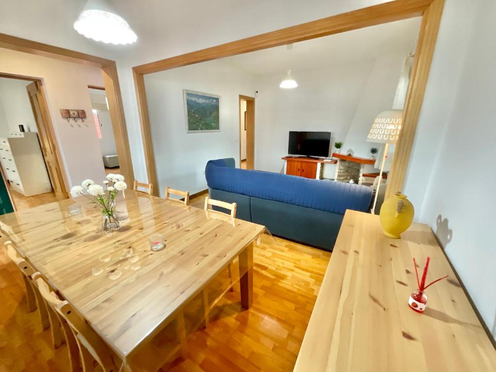 - un salon avec une table en bois et un canapé bleu dans l'établissement Big&Confort ''con terraza y jardín'', à Tegueste