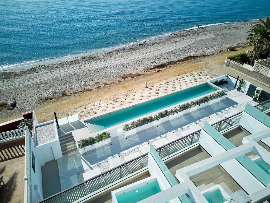 een luchtzicht op een strand met een zwembad bij Ancón Suites in Carboneras