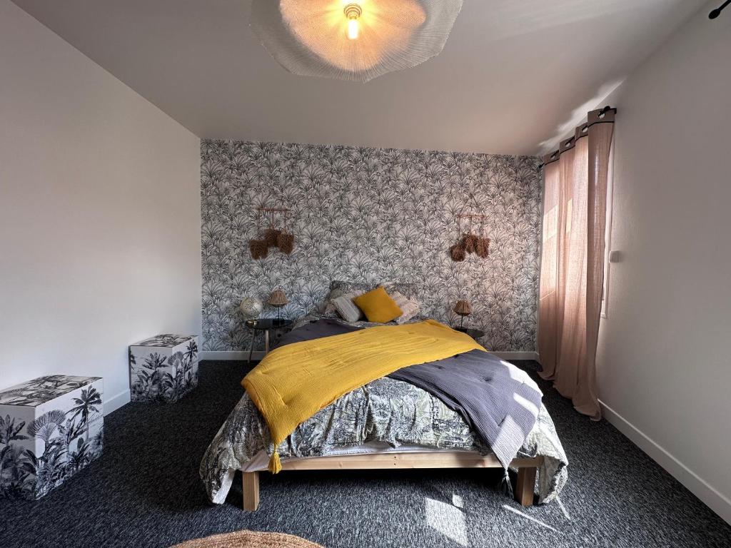una camera con un letto con una coperta gialla di Charmante maison à Rouen a Rouen