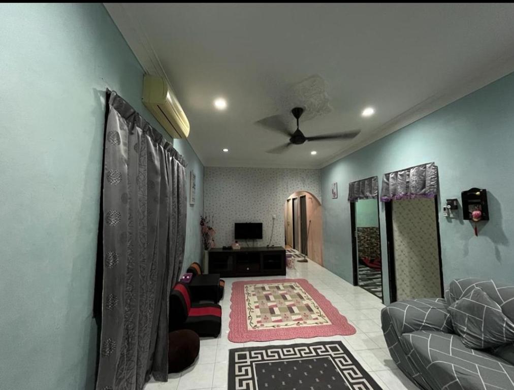 sala de estar con sofá y ventilador de techo en Homestay lumut manjung murah, en Lumut