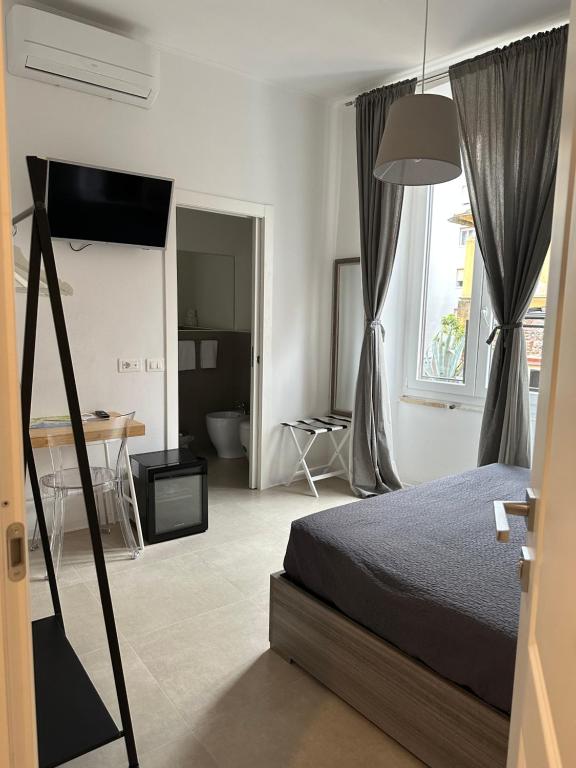 een slaapkamer met een bed, een bureau en een raam bij San Martino Rooms Third Floor No Lift in La Spezia